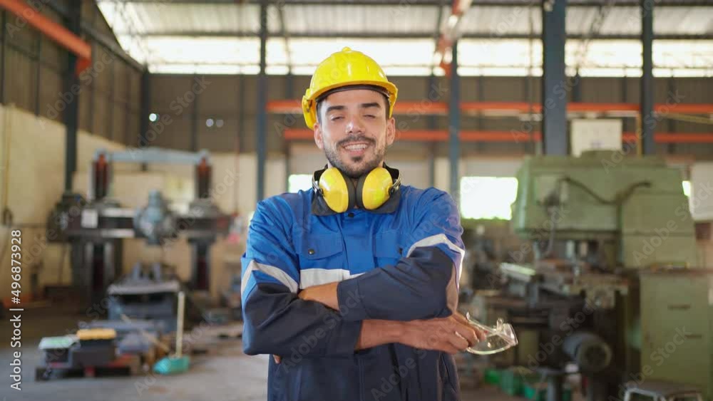 Portrait of two engineers standing in the CNC factory. Remove safety glasses and crossed arm in the production line with smile. High technology of machine. Industrial and good workplace concept Portrait of two engineers standing in the CNC factory. Remove safety glasses and crossed arm in the production line with smile. High technology of machine. Industrial and good workplace concept