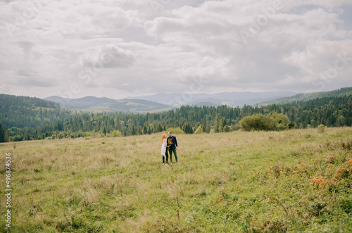 A loving young couple walks in the mountains and poses for the camera. Enjoy beautiful views, fresh air and be happy © ann