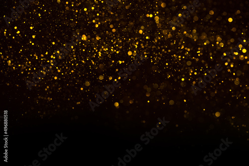 Abstract background of shiny golden glitter particles lights bokeh