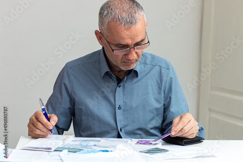 Close up of businessman busy calculating household finances or taxes expense from invoice or bill.