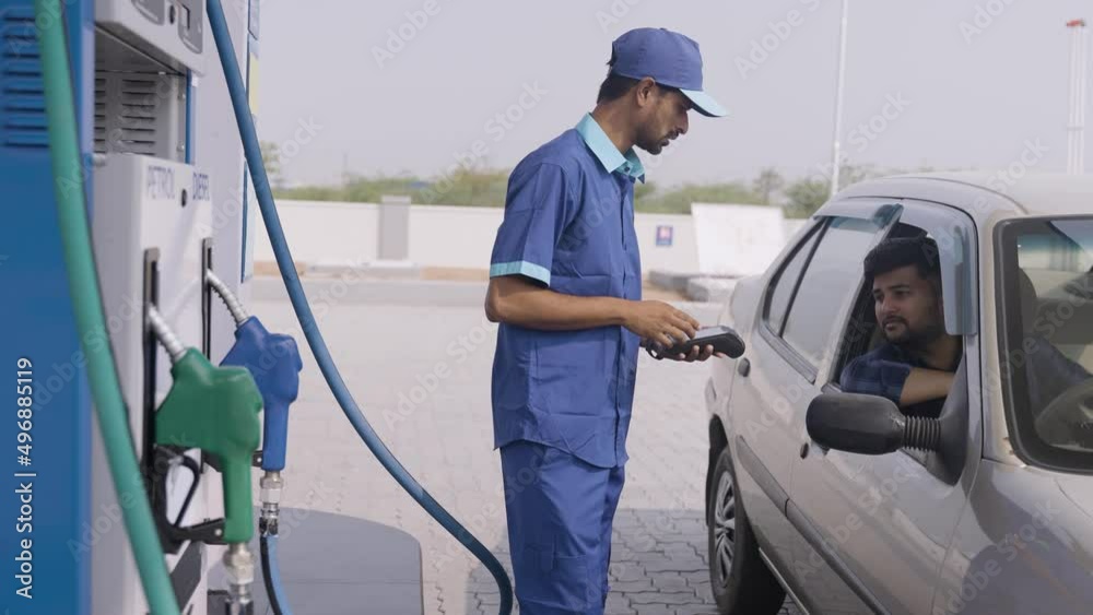 Customer doding payement using creadit card at petrol pump or gas filing station - concept of cashless transaction, technology and small business.