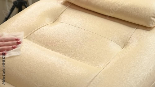 The cosmetologist wipes her working chair with a sterile napkin. Spa. Preparation of a workplace in a cosmetology clinic.