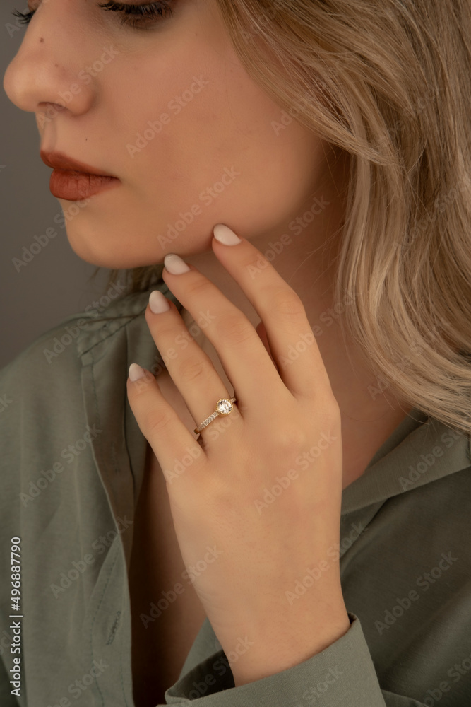 Young woman's hand wearing a diamond ring. wedding accessories bride.