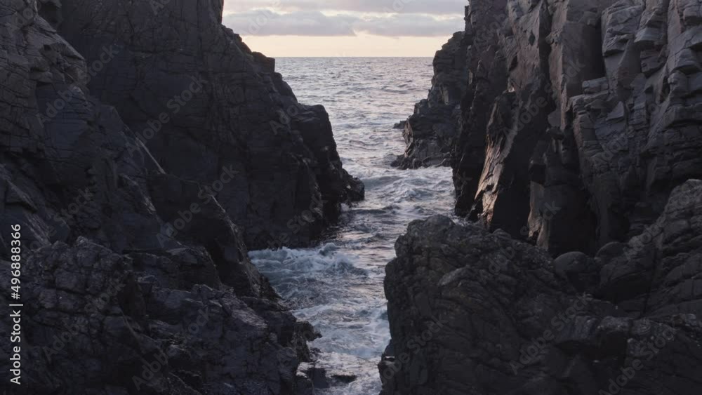 Tidal Waves rolling into rocky canyon at sunset in slow motion. Tidal Waves rolling into rocky canyon at sunset in slow motion.