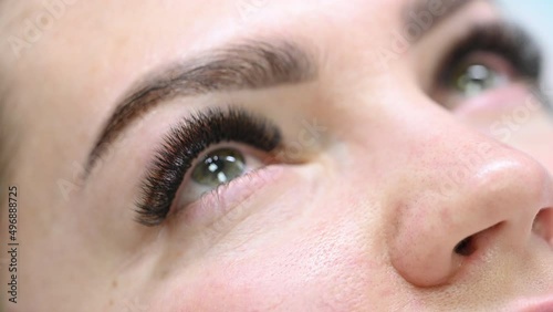 Beautiful girl opens her blue eyes after eyelash extensions