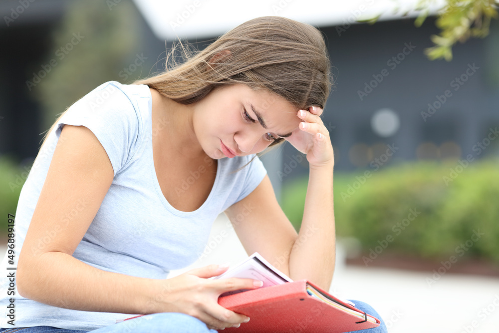 Concentrated student memorizing notes in the street Concentrated student memorizing notes in the street