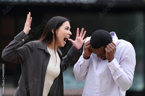 Angry woman scolding to a scared man photo