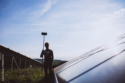 Man worker in the firld by the solar panels photo