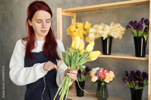 European flower shop concept. A female florist creates a beautiful bouquet of spring tulip flowers. Beautiful fresh bouquet. Education, master classes and floristry courses.