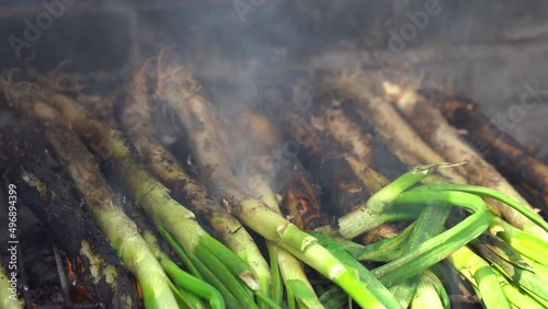 Closeup of a pile of calcots or sweet onions being cooked in the barbecue. Typical of Catalonia, Spain photo