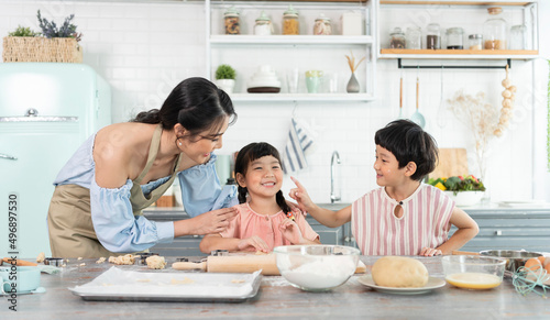 Happy Asian family making food in kitchen at home. Enjoy family activity together.