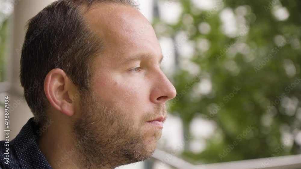 A Caucasian man thinks about something in an urban area - face closeup A Caucasian man thinks about something in an urban area - face closeup