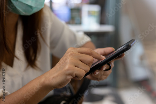 Asian Women sitting in a coffee shop using a smart phone for talking, reading and sending messages.