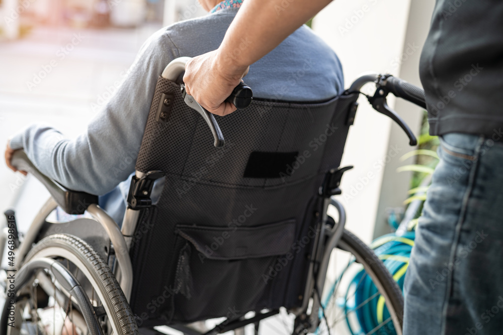 Obraz premium Caregiver help and care Asian senior or elderly old lady woman patient sitting on wheelchair at nursing hospital ward, healthy strong medical concept