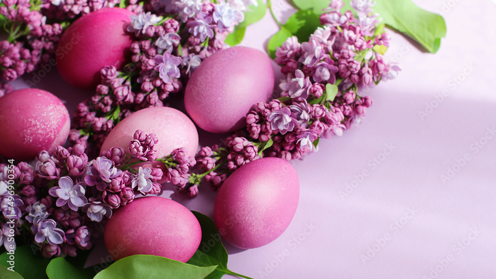 Fototapeta Close-up of beautiful lilac Easter eggs with blooming lilac branches. Easter decor. Selective focus.