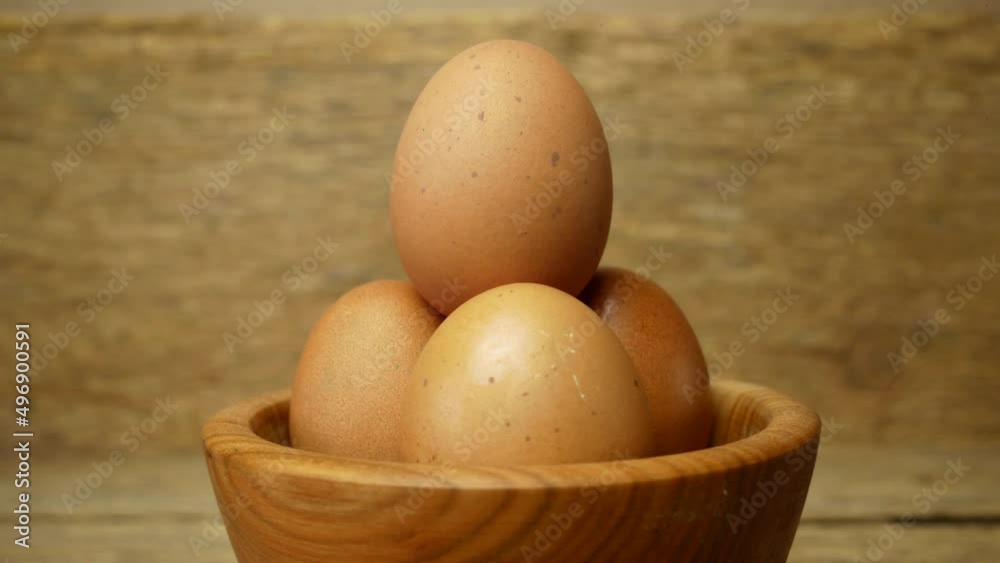 Rotation of eggs in a wooden plate on a wooden background. Easter concept.close up.Easter eggs Rotation of eggs in a wooden plate on a wooden background. Easter concept.close up.Easter eggs