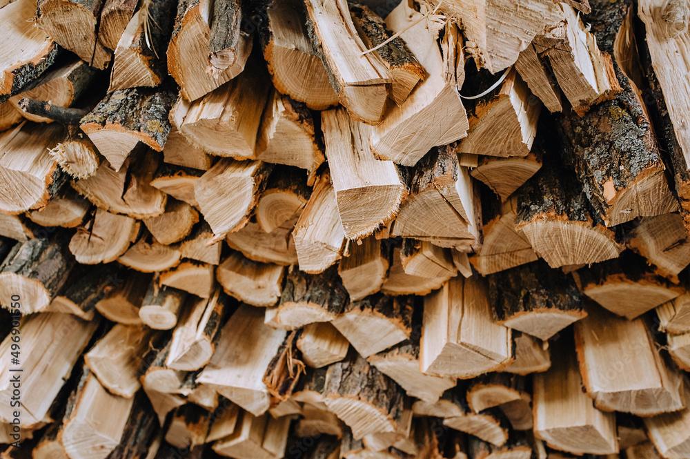 Logs chopped with an ax, dry acacia firewood, spruce for heating lie in a row close-up. Logs chopped with an ax, dry acacia firewood, spruce for heating lie in a row close-up.
