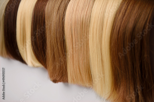 Selective focus ,hair extension equipment of natural hair. hair samples of different colors.Beautiful healthy shiny  Colors Palette. Hair Texture.