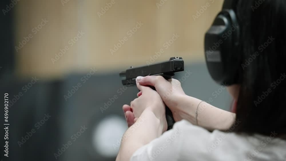 A woman practices shooting in a shooting range, shoots the last pistol ammo. sloiw motion