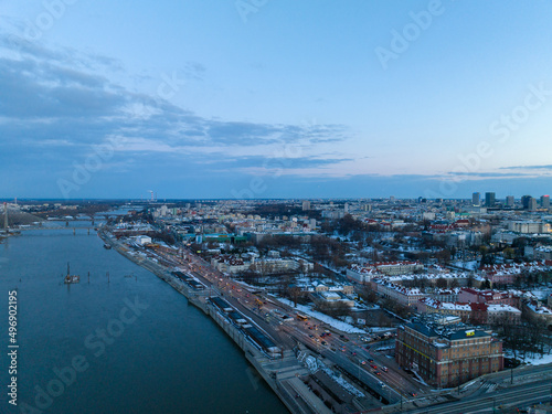Duża rzeka widziana z drona podczas zachodu słońca, Warszawa, widoczne zabudowania i brzeg, mosty