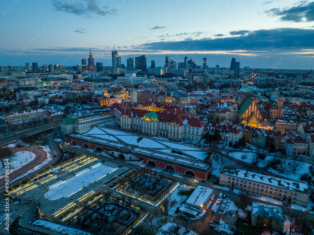 Obraz premium Widok na zamek królewki i stare miasto w Warszawie z drona, w tle wieżowce, zaśnieżone dachy, zachód słońca