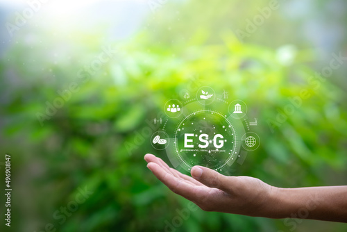 ESG icon concept in the hand of human for environmental, social, and governance in sustainable and ethical business on the network connection on nature background.