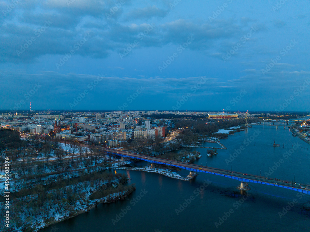 Duża rzeka widziana z drona podczas zachodu słońca, Warszawa, widoczne zabudowania i brzeg, mosty - obrazy, fototapety, plakaty 