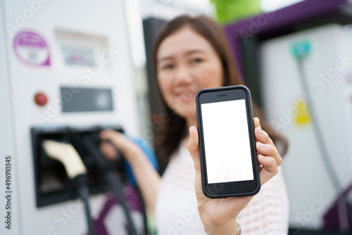 Empty screen of mockup smartphone isolated with clipping path. Asian young woman using ev charging application on smartphone.