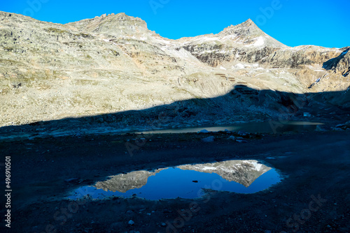 Panoramic view on the mountains of Hohe Tauern Alps in Carinthia, Austria, Europe. A lake reflection and water reservoir on the Moelltaler glacier. Hohe Tauern National Park. Valley in the shadow photo