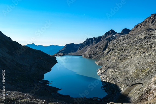 Panoramic view on the mountains of Hohe Tauern Alps in Carinthia, Austria, Europe. A lake reflection and water reservoir on the Moelltaler glacier. Hohe Tauern National Park. Valley in the shadow