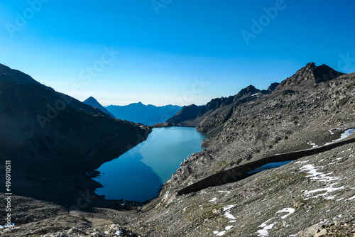 Panoramic view on the mountains of Hohe Tauern Alps in Carinthia, Austria, Europe. A lake reflection and water reservoir on the Moelltaler glacier. Hohe Tauern National Park. Valley in the shadow photo