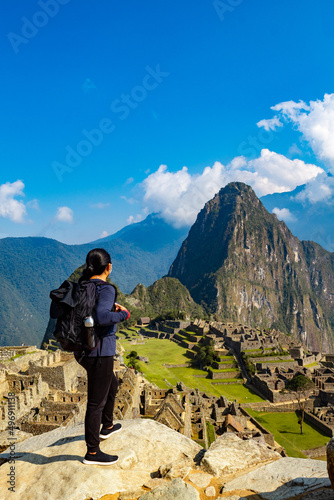 mujer turista con mochila mirando machu picchu en Perú