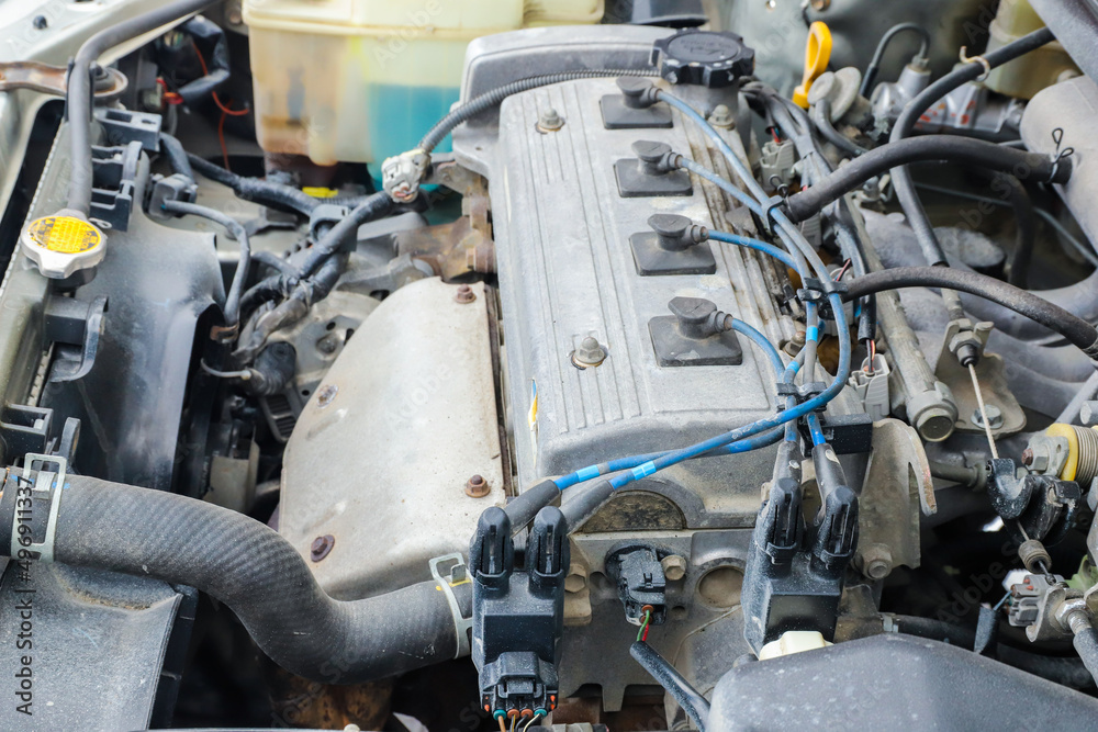 Fototapeta premium Old dirty engine under the hood of a car close-up