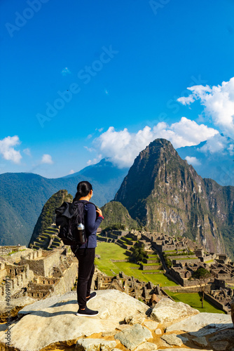 Viajera de pie mirando la antigua ciudadela de Machu Picchu, Patrimonio de la Humanidad de la UNESCO en la región del Cusco en el Perú