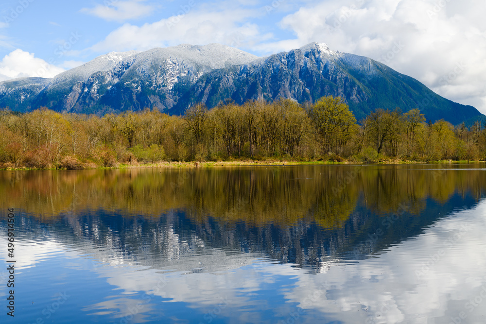 Spring snow on the peak of Mount Si in Snoqualmie Washington with the scene reflecting in Boarst Lake also known as Snoqualmie Mill Pond