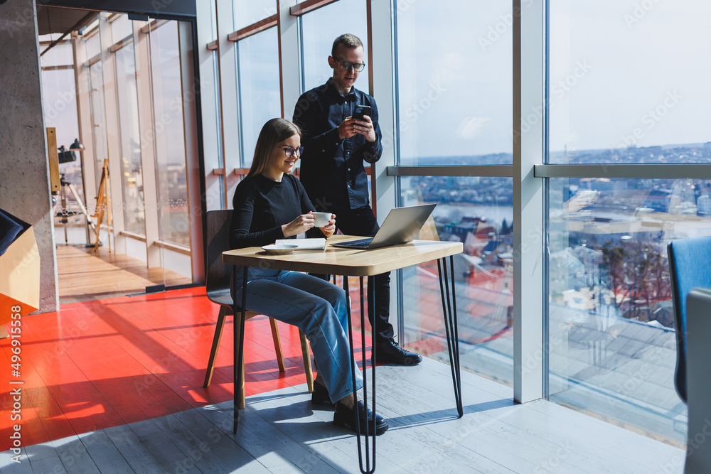 Young business woman behind a laptop wearing glasses sitting at a table having a corporate business meeting with colleagues in a modern office. Business career concept. Free space, selective focus Young business woman behind a laptop wearing glasses sitting at a table having a corporate business meeting with colleagues in a modern office. Business career concept. Free space, selective focus
