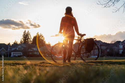 Adventurous Woman Standing with a bicycle at a Park in Modery City Suburbs. photo