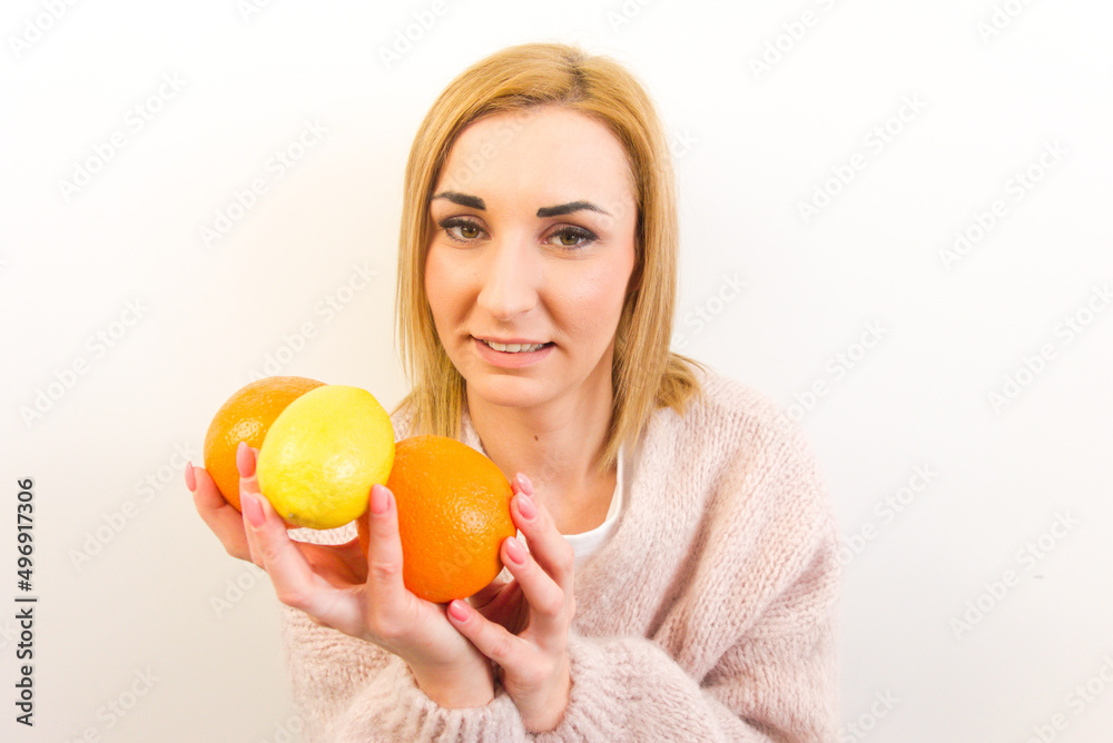 Close-up portrait of attractive healthy young woman holding citrus fruits isolated on white background Close-up portrait of attractive healthy young woman holding citrus fruits isolated on white background