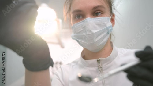 Dentist examining patient's teeth, first person view.