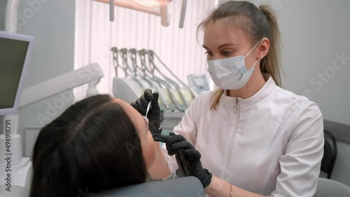 Female dentist examining a woman patient in modern dental office. Doctor at work in stomatology dentistry. Teeth research