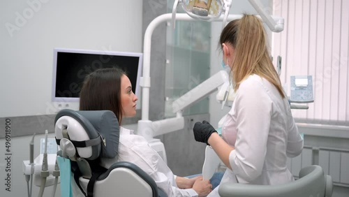 Female dentist examining a woman patient in modern dental office. Doctor at work in stomatology dentistry. Teeth research