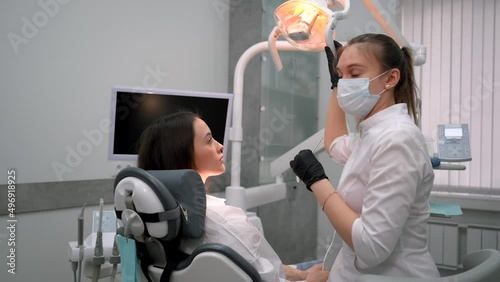 Female dentist examining a woman patient in modern dental office. Doctor at work in stomatology dentistry. Teeth research