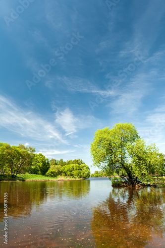 Bright summer landscape with beautiful lake and blue sky with clouds.