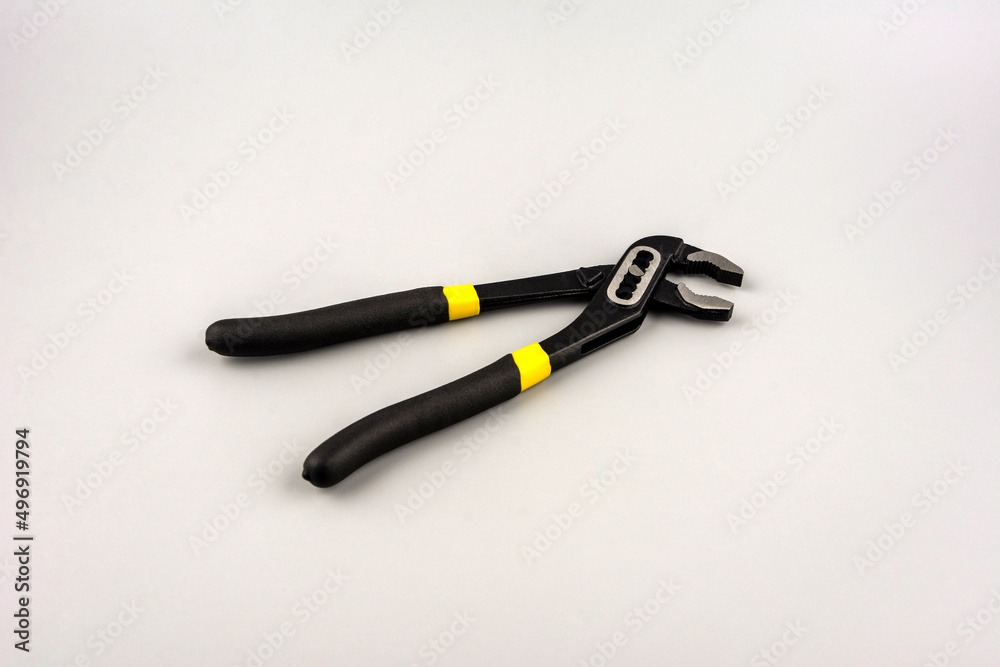Tongue-and-groove slip-joint pliers detail with movable jaw on a white background. Tongue-and-groove slip-joint pliers detail with movable jaw on a white background.