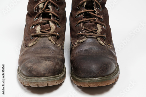 Women's brown nubuck boots - one dirty, the second clean on a white background. Shoe care.