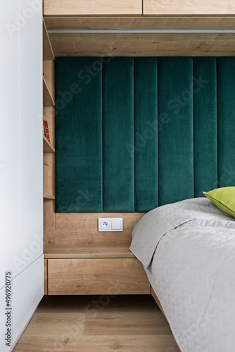 Mała sypialnia z pojemnymi szafami, zielonym zamszem i półkami