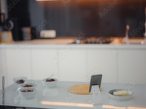 The concept of online lessons in preparation of cookies. smartphone and ingredients are on table. Everything is ready for mixing future baking. © YURII Seleznov
