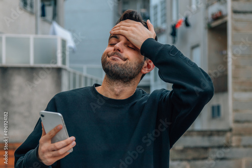 man with mobile phone and expression of resignation