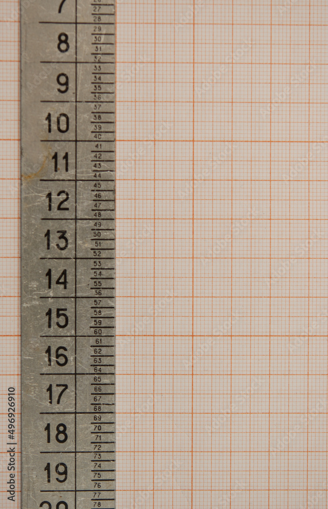 ruler made from metal lie on a graph paper with copy space for text. Math graphic tools concept. ruler made from metal lie on a graph paper with copy space for text. Math graphic tools concept.