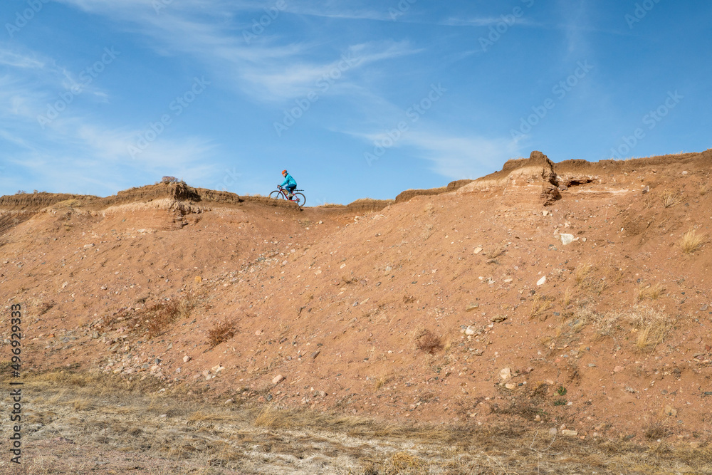 male cyclist is riding a gravel bike on cliff edge in Colorado prairie - Soapstone Prairie Natural Area male cyclist is riding a gravel bike on cliff edge in Colorado prairie - Soapstone Prairie Natural Area
